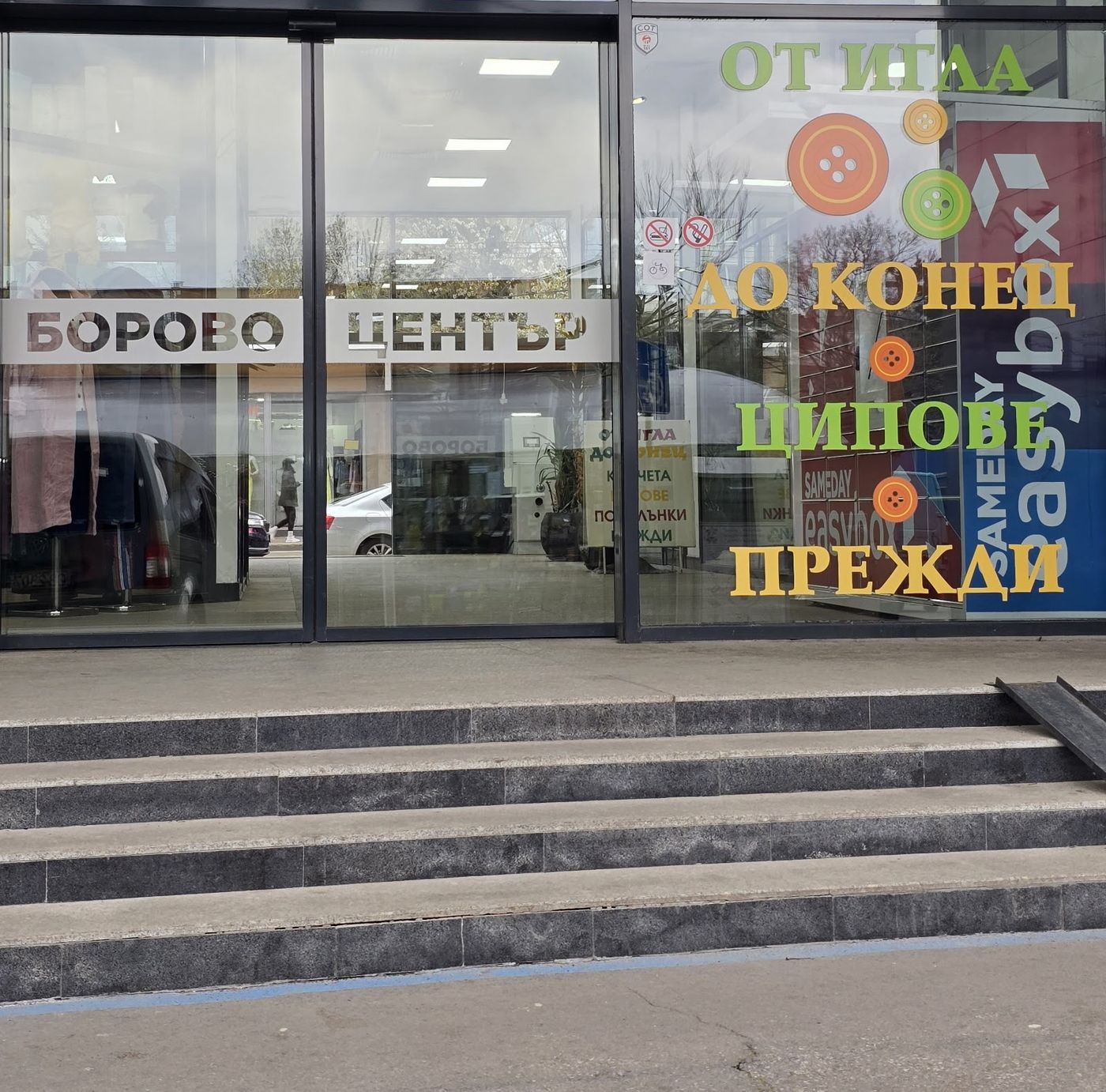 Входът на ТЦ „Борово Център“ с надпис на витрината: От игла до конец — ципове, прежди.